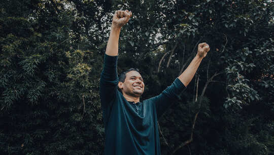 man with arms raised in the air in triumph