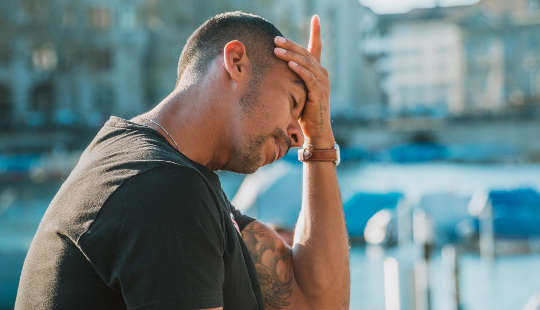 a man sitting holding his head