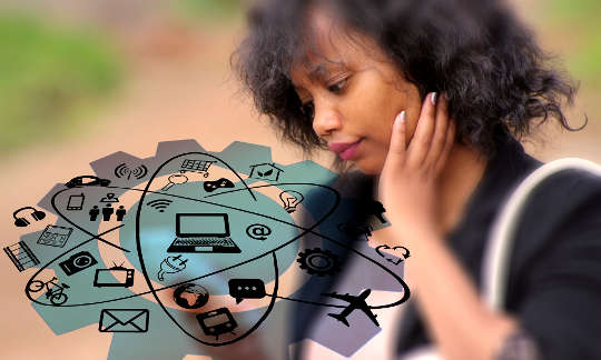 a young woman looking at her phone with its many apps and possibilities