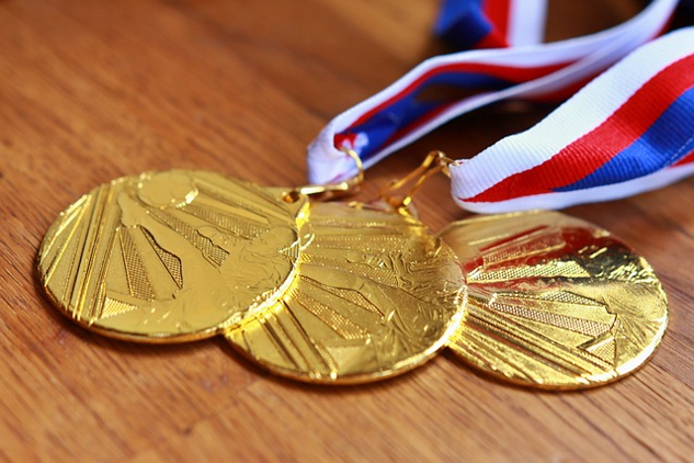 three gold medals on ribbons