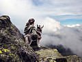 woman sitting outside with her arm around a husky dog