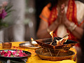 a person in meditation in front of a bowl of flower petals and a bowl of fire