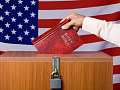 someone dropping a Bible into the ballot box in front of an American flag backdrop