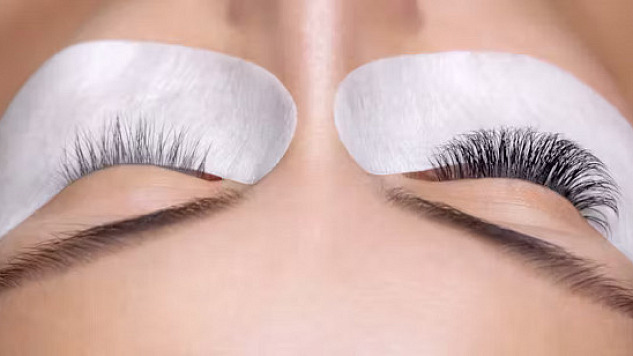 Close-up of a woman's eye with eyelash extensions, highlighting potential health