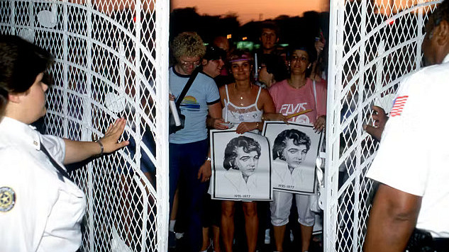 Fans at the gates of Graceland commemorating Elvis Presley, reflecting the cultural significance of his legacy.