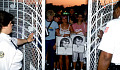 Fans at the gates of Graceland commemorating Elvis Presley, reflecting the cultural significance of his legacy.