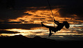 woman on a swing, happily swinging through the air. at sunset