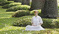 a woman in a white dress sitting in meditation