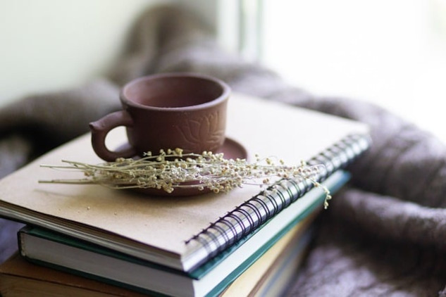 a cup with herbs next to it