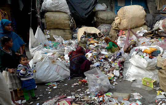 An Indian woman sorts reusable and recyclable materials from collected garbage in northeast Delhi.