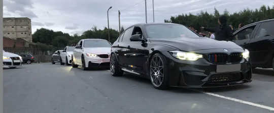 BMW and other vehicles parked in carpark.