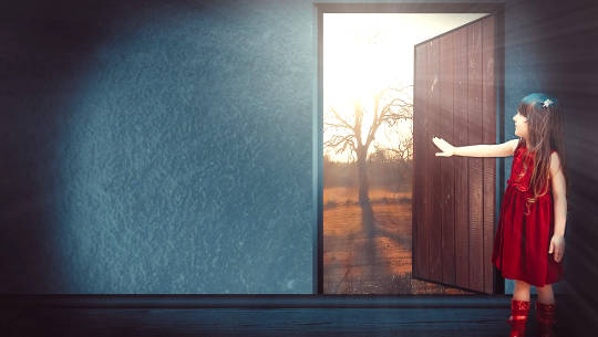 young girl opening a door to the outside