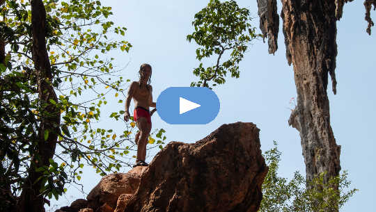 a young boy climbing to the top of a rock formation