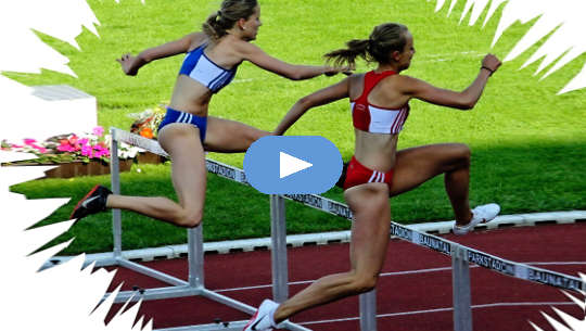 two women track runners jumping a hurdle