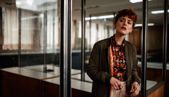 concerned-looking woman standing in an office setting