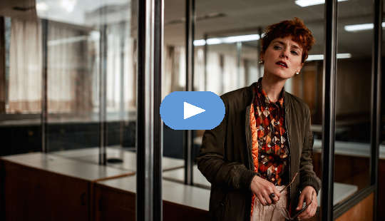 concerned-looking woman standing in an office setting