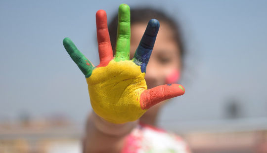 little girl with her fingers all in different hand painted colors