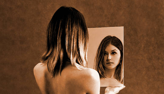 woman looking at herself in the mirror