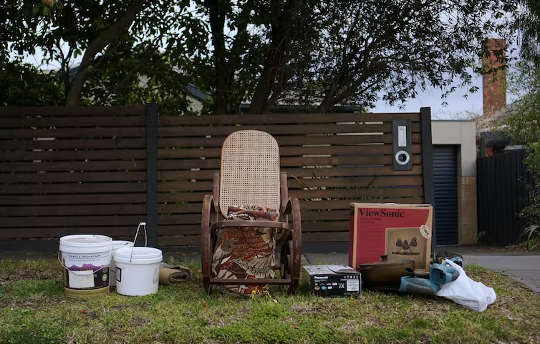 an old rocking chair sitting out for garbage pickup