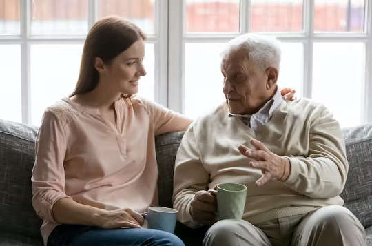 an older man speaking with a young adult over a cup of tea