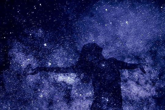 silhouette of a woman overlaid on a background of a starry galaxy