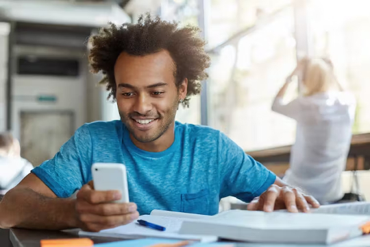 a man smiling while looking at his phone