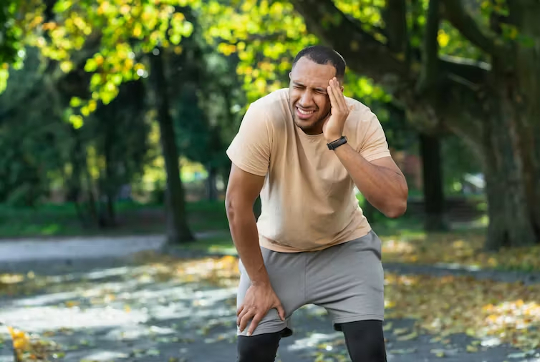 a man holding his head in pain