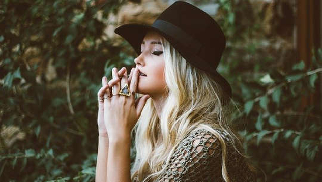 a young woman with her eyes closed in thought