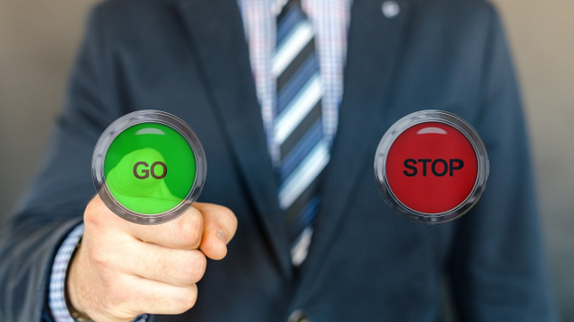 a man choosing to push the go button rather than the stop button