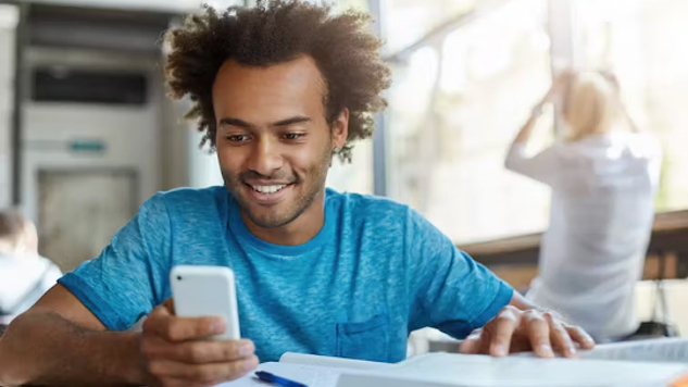 man laughing at something on his phone