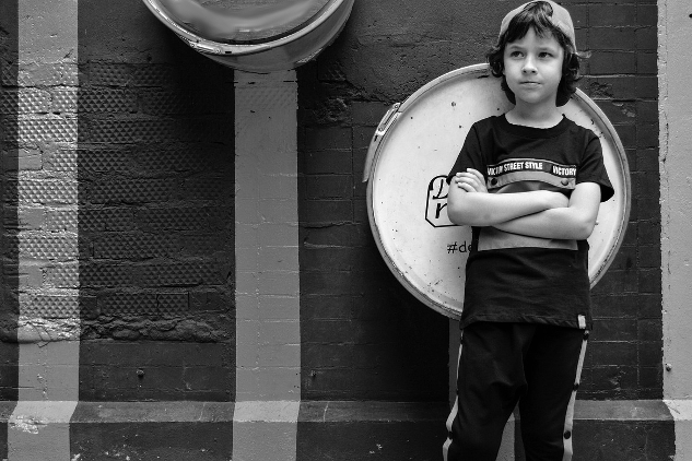 young boy standing with arms crossed