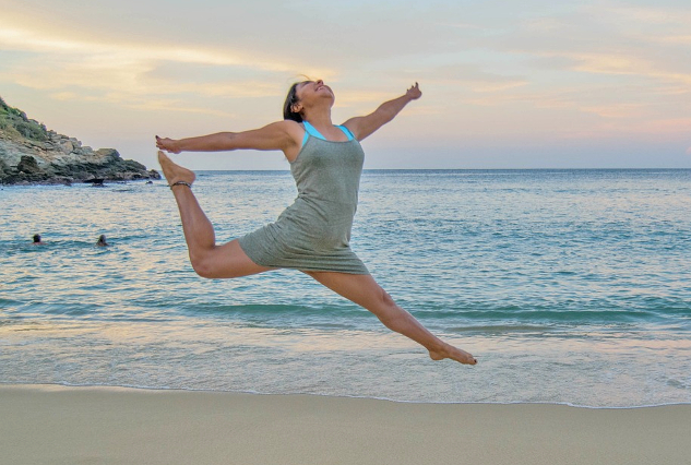 woman jumping and dancing on the beach