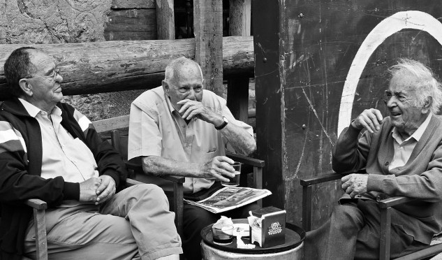 three older men sitting around talking