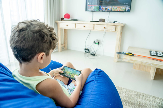 young boy playing a game on a smart phone