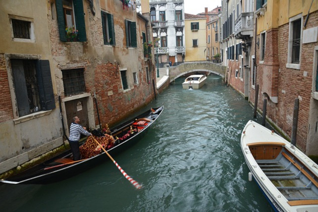 a gondola and other boats on a canal in Venice, Italy