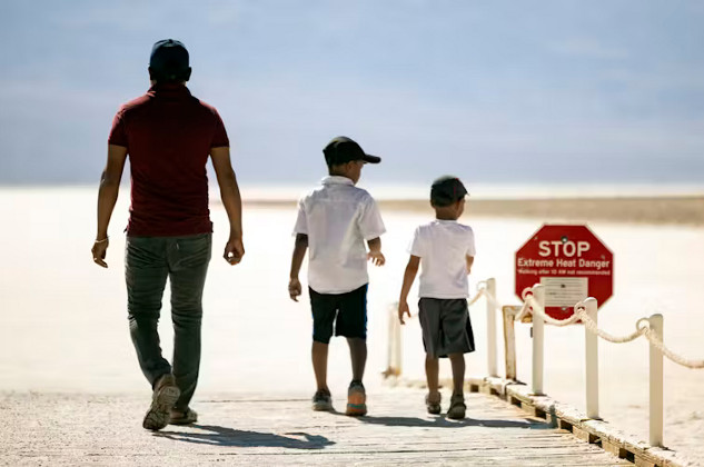 Sign warning of extreme heat danger in Death Valley during record-breaking heat waves in July 2024, highlighting climate change’s growing impact on global temperatures.  