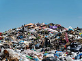 Suggested Alt Image Text:  A degraded landfill leaking into nearby soil and water, illustrating the ongoing threat of PCB pollution to the environment.