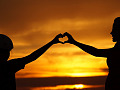 a woman anc child creating a heart shape with their hands touching