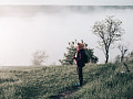 a woman wearing a scarf standing on a hillside