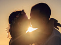 two people kissing with the light shining brightly behind them