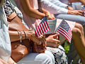 people sitting in a stadium holding small flags in their hands