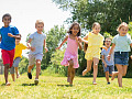 Preschoolers playing and engaging in physical activities outdoors, highlighting the importance of movement guidelines for child health and development.