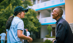 a young person speaking with an elderly man