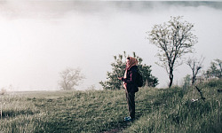 a woman wearing a scarf standing on a hillside