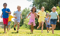 Preschoolers playing and engaging in physical activities outdoors, highlighting the importance of movement guidelines for child health and development.