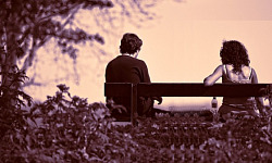 two people sitting far apart on a bench