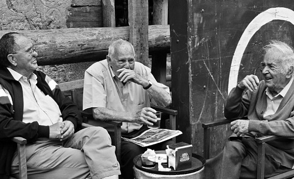 three older men sitting around talking