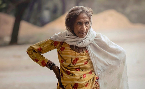 an older woman standing outside with a very determined expression