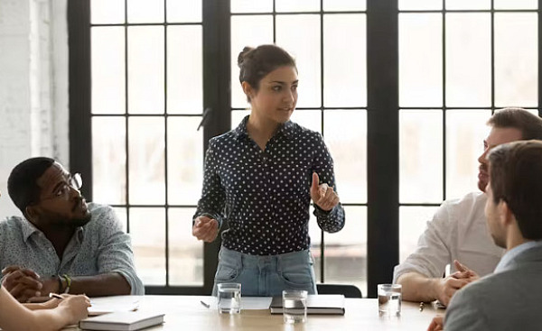 A young leader sitting at a desk, confidently reviewing documents and charts, symbolizing the process of making thoughtful, strategic decisions in a high-pressure work environment.