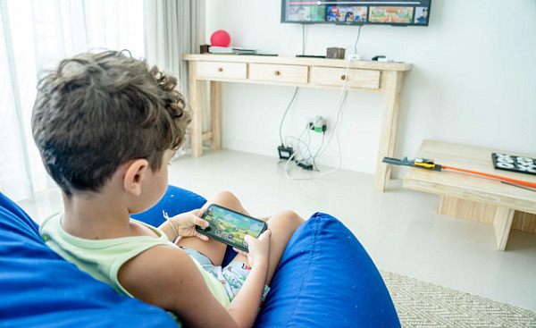 young boy playing a game on a smart phone